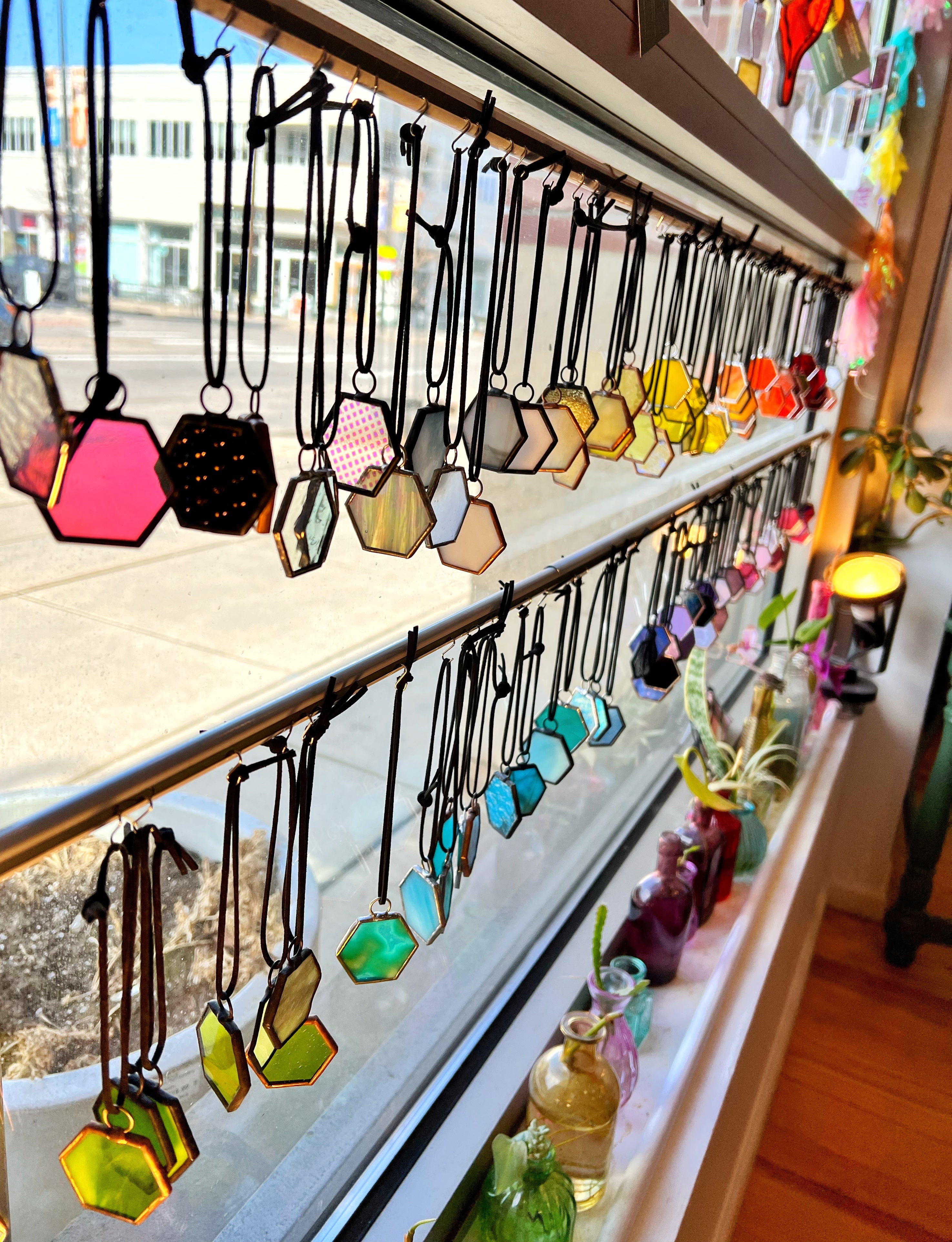 Photo of stained glass charms in the window of the studio