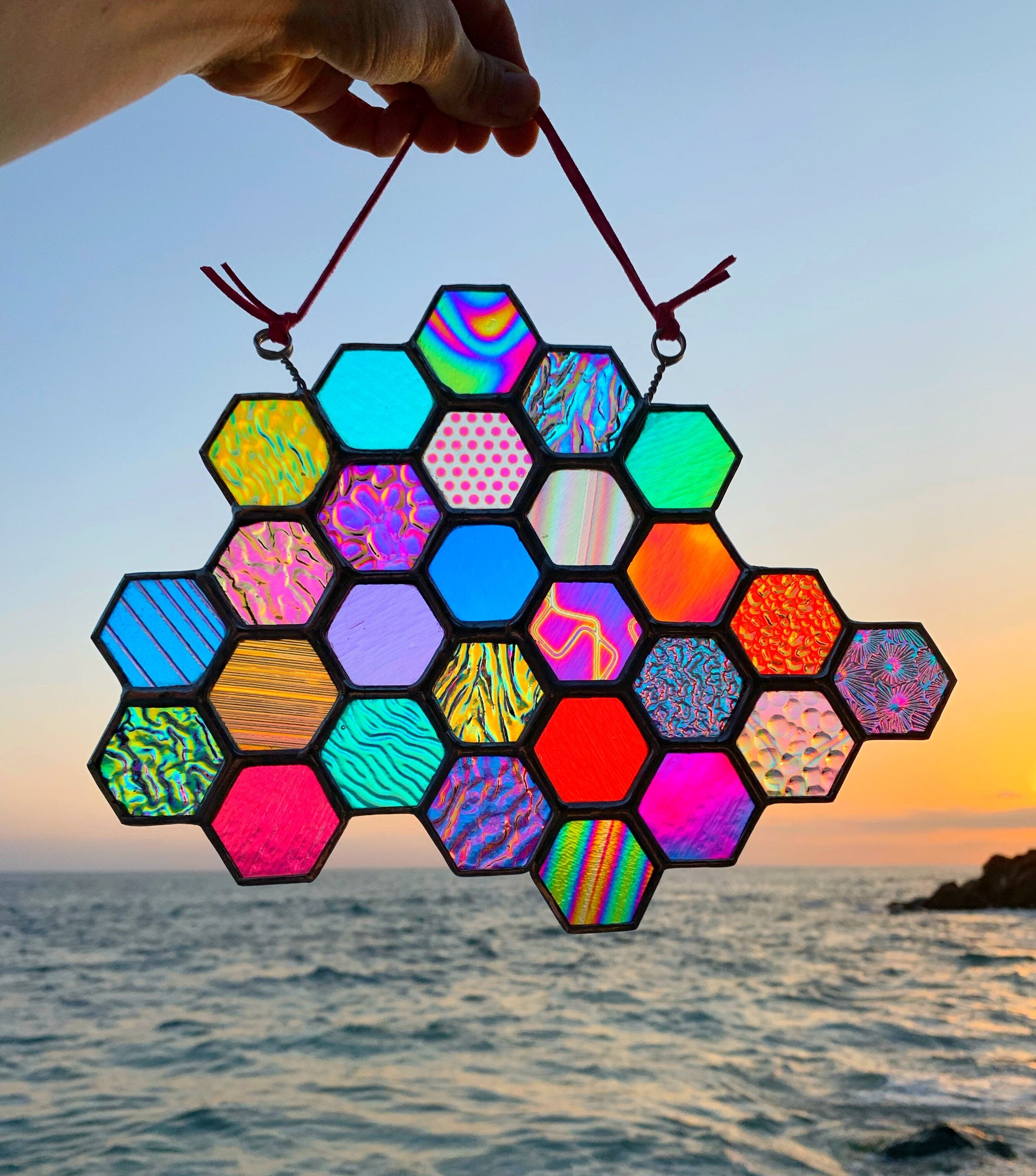 Image of rainbow stained glass art with several different color and pattern hexagons coming together