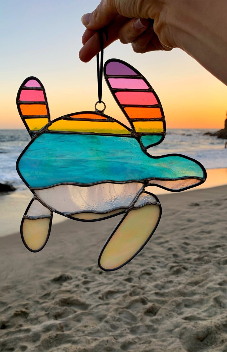 Turtle stained glass art with the beach in the background