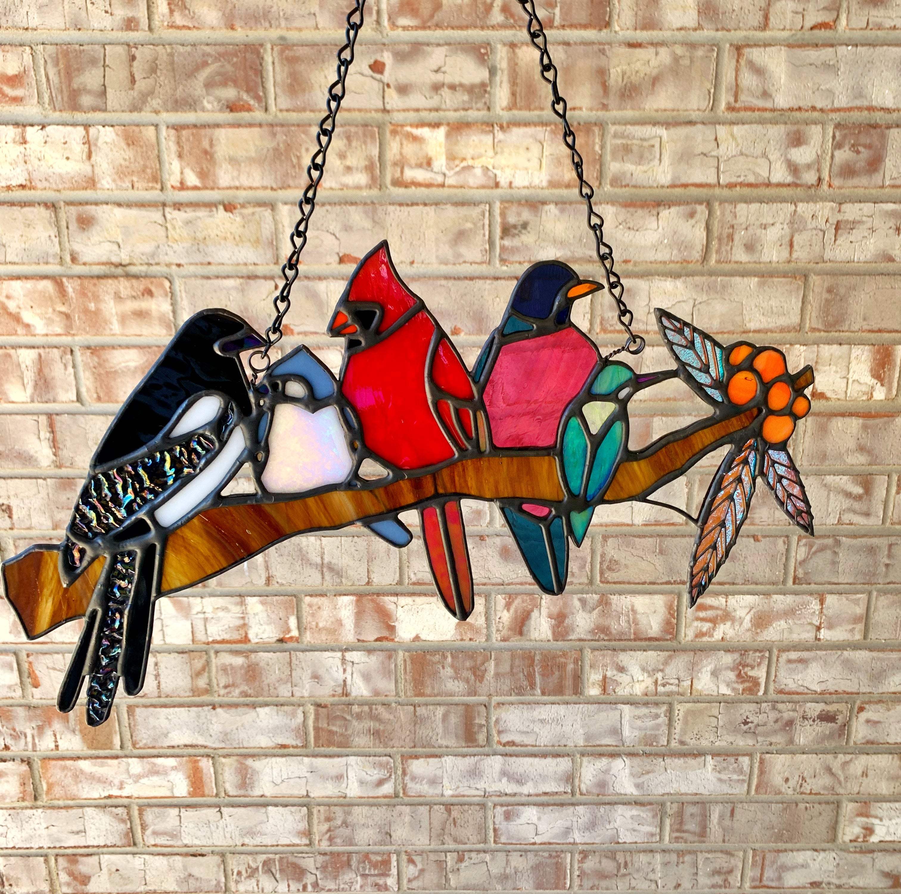 Stained glass art of several birds on a log