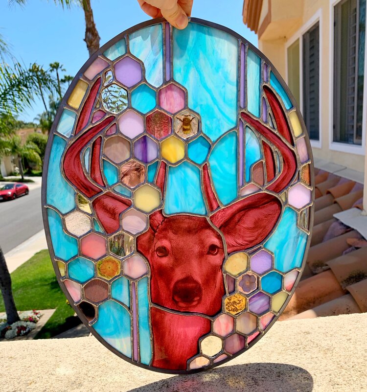 Stained glass art with a deer in the center