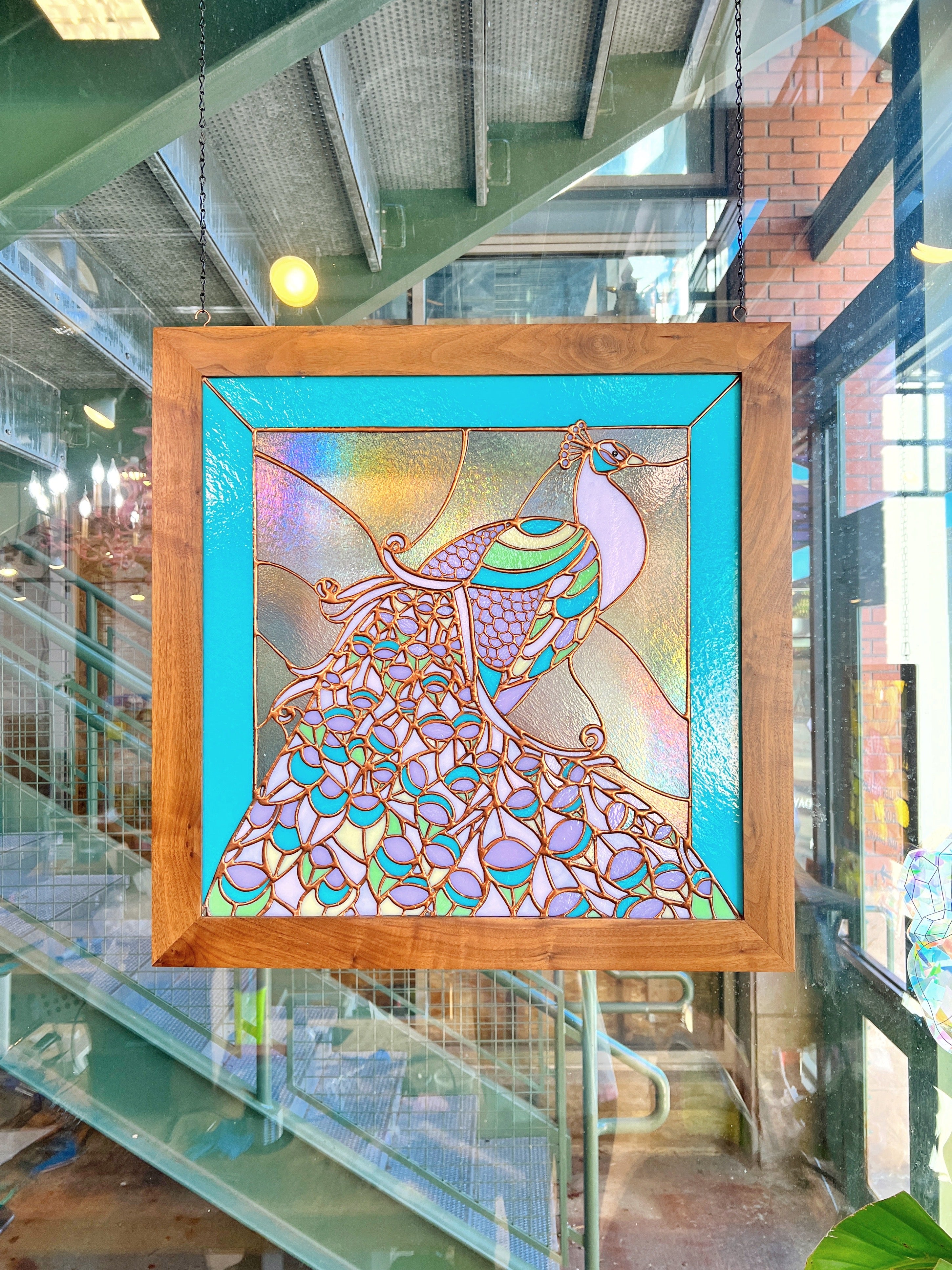 A large pastel stained glass peacock window