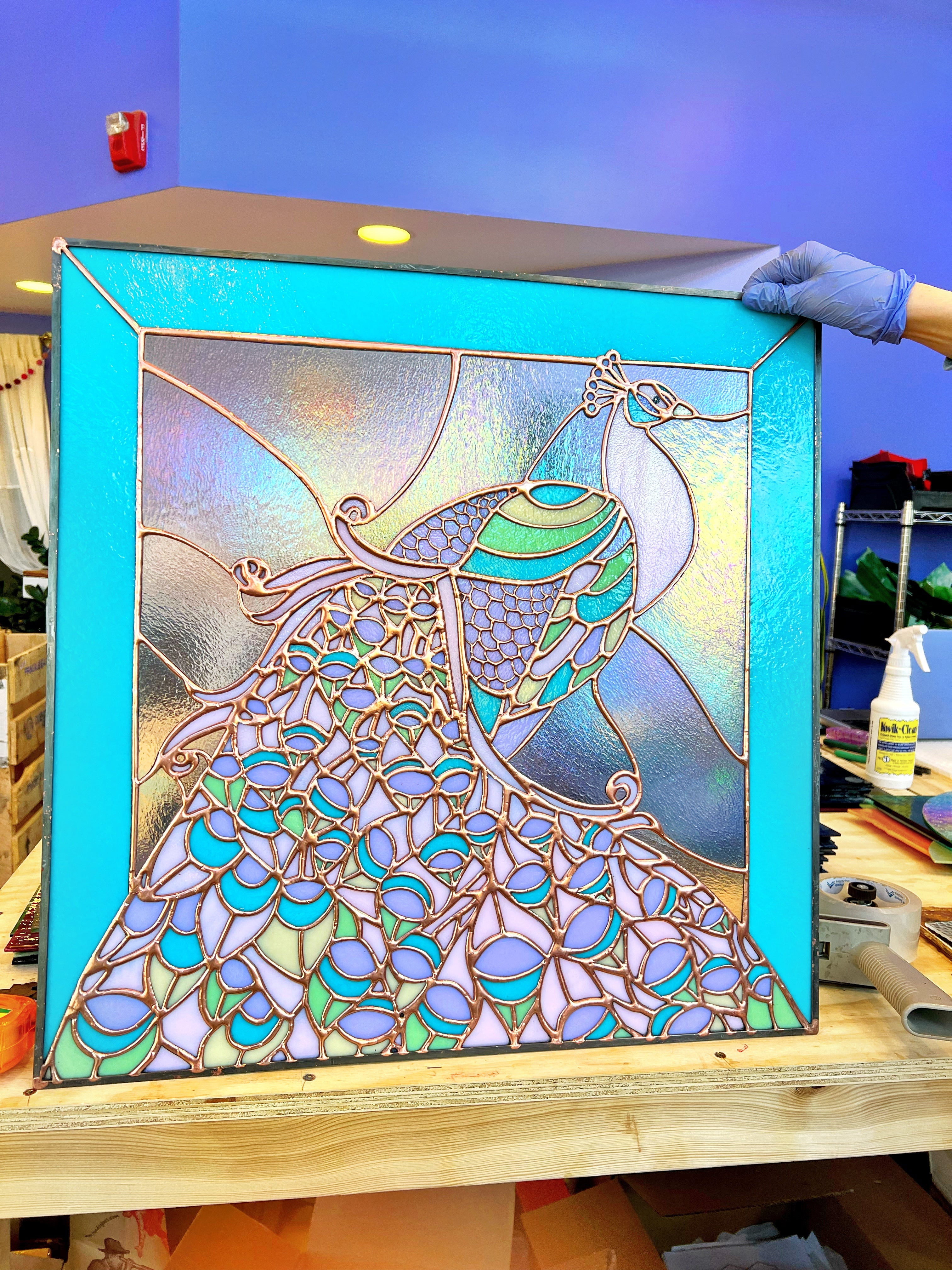 Peacock stained glass art with blues, purples and greens