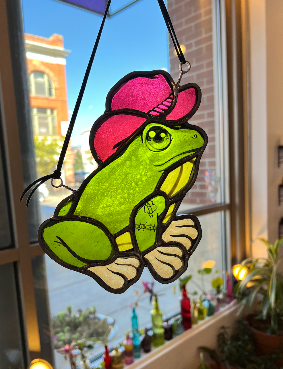 stained glass frog wearing a hat